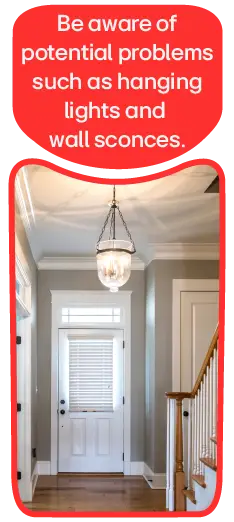 A staircase with a low-hanging ceiling light.  Be aware of potential problems such as hanging lights and wall sconces.